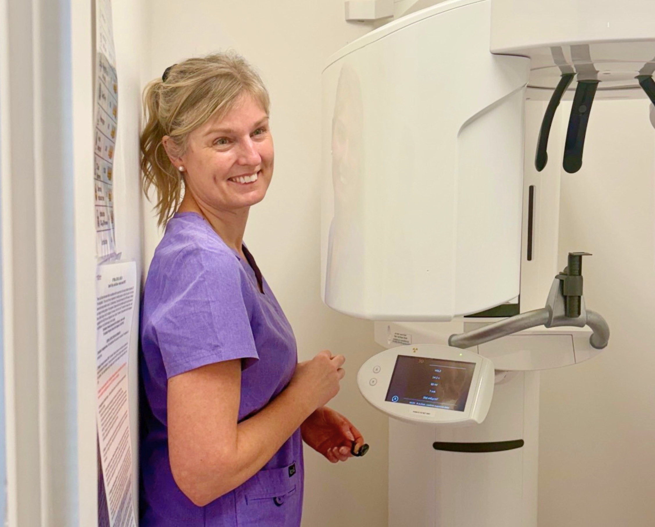an image of our dental nurse standing next to a CBCT 3d scanner in optimal dental health london