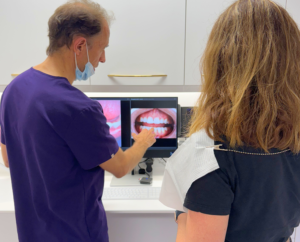 an image of dr james goolnik showing a patient a photos of their teeth in a clinical dentall setting london