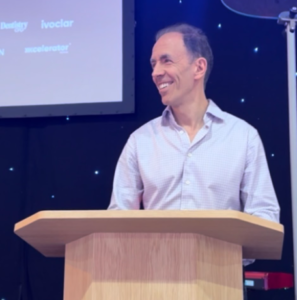 dr james goolnik standing at a speech podium