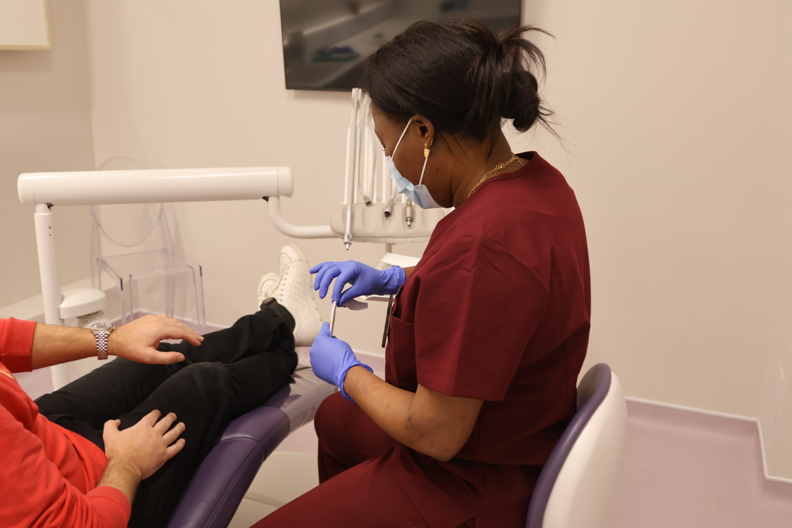 dental nurse marie providing a patient with rapid blood testing in london wearing dental scrubs
