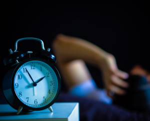 a close up of a black alarm clock to promote sleep health