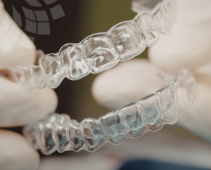 a close up image of clear aligners in london with the optimal dental health flower logo