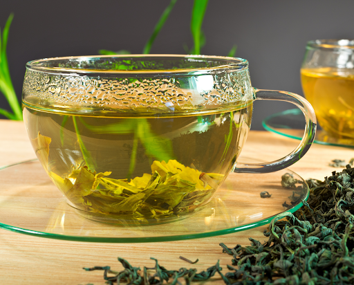 a photo of a glass mug of green tea and oral health benefits